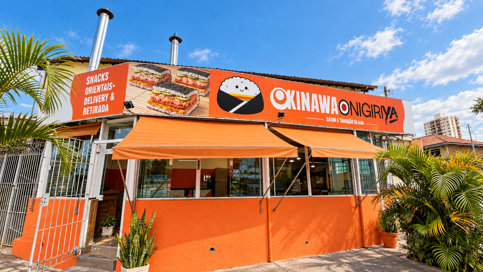 Fachada oficial da Okinawa Onigiri Ya em São Paulo, com placa, entrada e toldos laranja